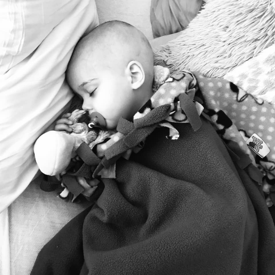 baby with cancer sleeping in crib
