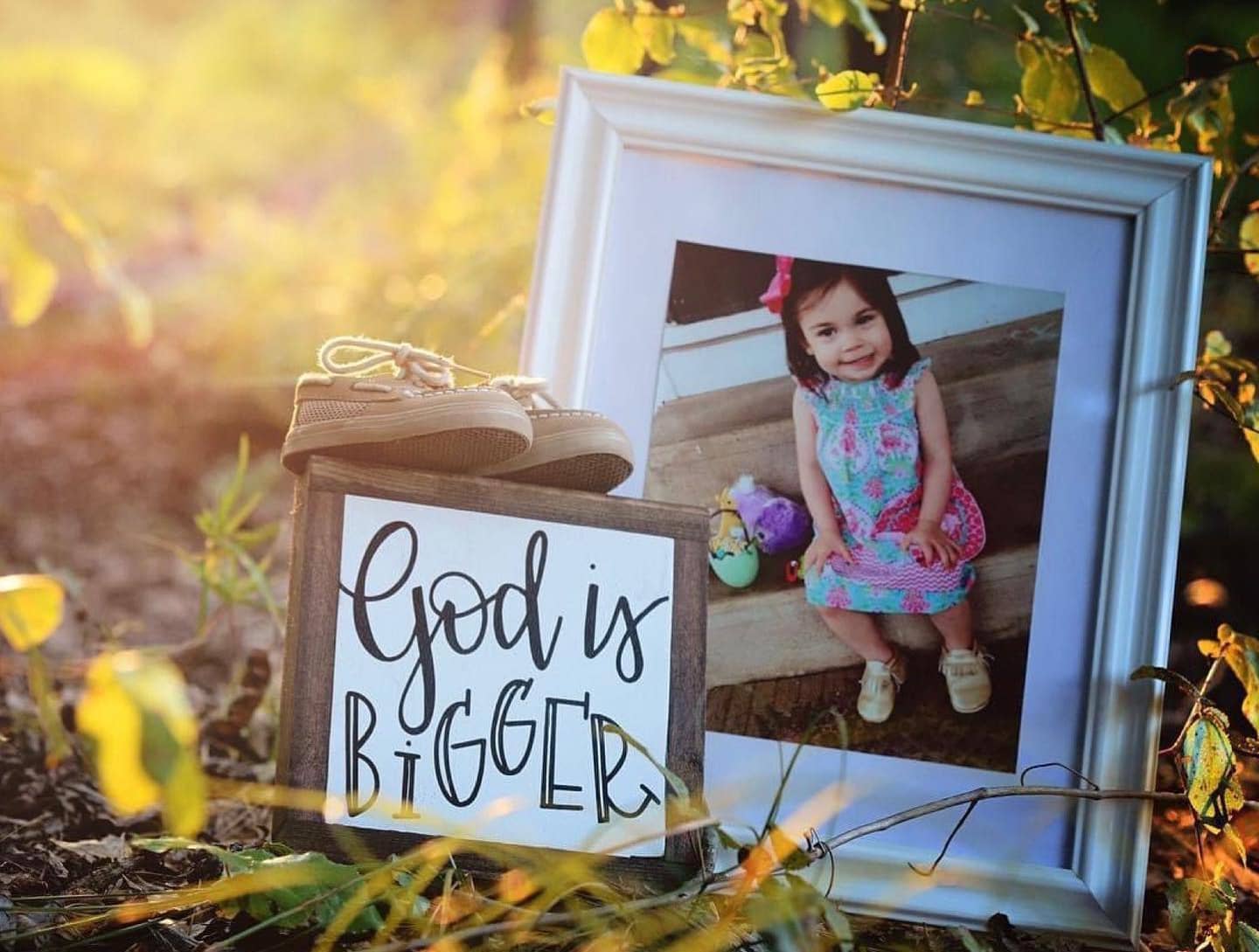 Photo of Sophie Skiles and a sign that says God Is Bigger